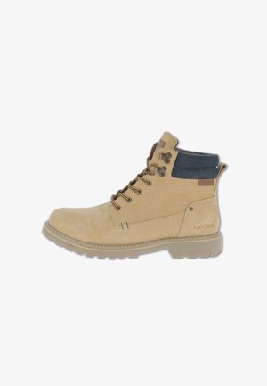 Stivale alla caviglia in suede tan con collo in tessuto blu, punta rotonda e dettagli marroni. Presenta occhielli metallici e una suola in gomma testurizzata. Logo sul lato.