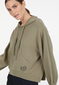 Olivgrüner Kapuzenpullover mit lockerer Passform, geripptem Saum und Kordeln; verfügt über eine Vordertasche mit gesticktem Herzlogo.