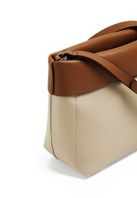 Sac à main bicolore avec une section inférieure lisse beige et une partie supérieure marron. Présente un design structuré, des coutures subtiles et une bandoulière ajustable.