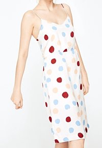 Vestido de satén tipo slip con base blanca y grandes lunares rojos, azules y melocotón, con tirantes finos y un corte relajado.