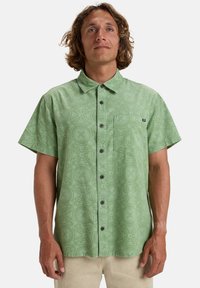 Korte mouwen groene button-up shirt met een algeheel geometrisch patroon, een borstzak en donkere knopen. Gemaakt van een lichtgewicht stof.