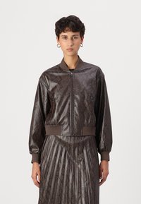 Chaqueta bomber de imitación cuero marrón con patrón de piel de serpiente, puños y cinturilla acanalados, y bolsillos con cremallera. Textura suave, diseño a la moda.