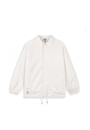 Chaqueta ligera blanca con cuello, botones a presión, puños elásticos y dobladillo con cordón. Cuenta con dos bolsillos laterales y una etiqueta de la marca.