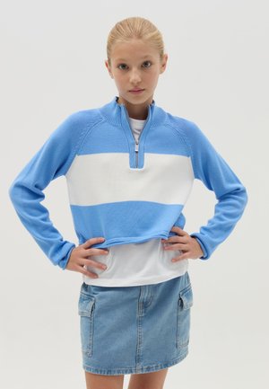 Blauw-wit gestreepte cropped sweatshirt met een kwart-rits kraag, gecombineerd met een denim rok met zijkanten zakken. Stijlvolle gebreide textuur.