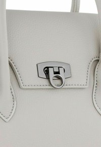 Witte leren handtas met een textuur, een zilverkleurige hardware sluiting en contrasterende stiknaad rondom de randen.