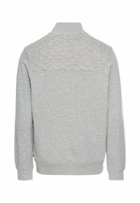 Sweatshirt gris clair avec un col haut, panneau arrière supérieur matelassé, manches longues, poignets et ourlet côtelés, et une petite étiquette logo sur le côté.