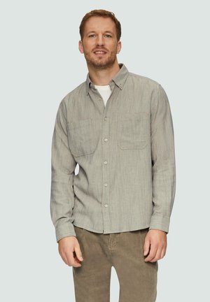 Grijs herringbone-patroon overhemd met knopen, voorzien van twee borstzakken en een kraag. Draag het over een wit t-shirt, gecombineerd met ribfluwelen broek.