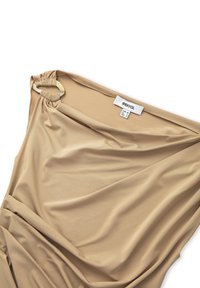 Beige gedrapeerde jurk van gladde stof, met een geplooid schouderdetail en een cirkelvormige ring, en een label met informatie over de maat.