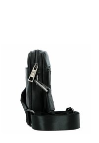 Borsa nera in pelle con una superficie liscia, dotata di una cerniera verticale e di una tracolla in nylon removibile. Accentuata da accessori in metallo.