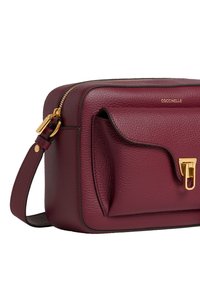 Borsa a tracolla in pelle bordeaux con finitura testurizzata, hardware dorato, tasca frontale a patta e tracolla regolabile.