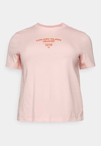 Růžové bavlněné tričko s kulatým výstřihem, krátkými rukávy a potiskem loga "CALVIN KLEIN JEANS 1978" ve tmavší růžové barvě přes hrudník.