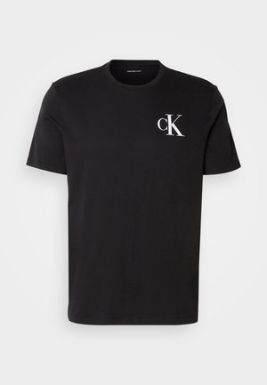 Camiseta de algodón negra de manga corta con un logo blanco "ck" en el lado izquierdo del pecho. Cuello redondo y diseño de dobladillo recto.