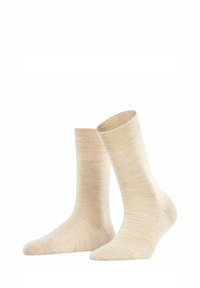 Chaussettes beige en matériau doux, avec une texture lisse et une hauteur moyenne, au design simple et sans embellissement.