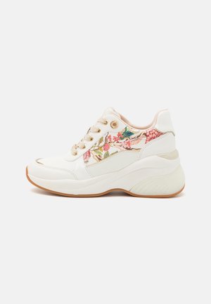 Hvid sneaker med tyk sål og blomsterstofpanel med pink og grønne blomster på siden, beige snørebånd og gummisål.