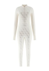 Body à manches longues zippé de couleur beige clair avec un motif subtil en losange beige plus foncé, doté d'un tissu lisse et d'une silhouette ajustée.