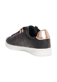 Sneaker nera con motivo floreale perforato, accento bronzo sul tallone, suola in gomma bianca e linguetta nera. Presenta lacci piatti e interno imbottito.