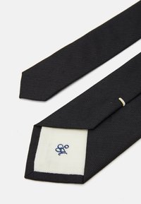Schwarze strukturierte Krawatte mit schlankem Design. Verfügt über eine weiße Fütterung mit einem blauen Monogramm. Endet in einer spitzen Form.