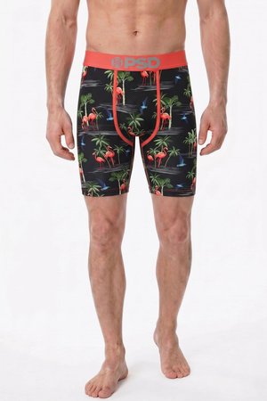 Homme portant un boxer noir avec un imprimé tropical de flamants roses, palmiers et oiseaux bleus, et une ceinture rouge avec le logo PSD.