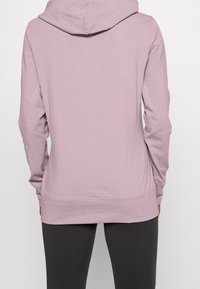 Světlý fialový mikina s texturovaným vzorem, dlouhými rukávy a kapucí. Má pružný spodní lem a manžety pro pohodlné nošení.