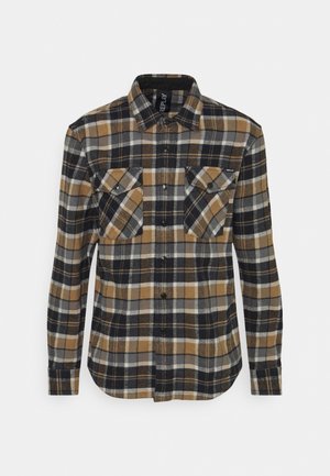 Pitkähihainen nappipaita, jossa on ruskea, musta, harmaa ja valkoinen ruutukuosi, kaksi etupuolen läpällistä taskua ja kaulus.