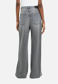 Wide-leg jeans in gray denim with a faded finish, featuring a high waist, back pockets, and a clean, raw hem.
