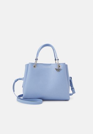 Bolso de cuero azul claro con dos asas superiores, correa de hombro desmontable y charm de logo plateado en el frente, sobre fondo blanco.