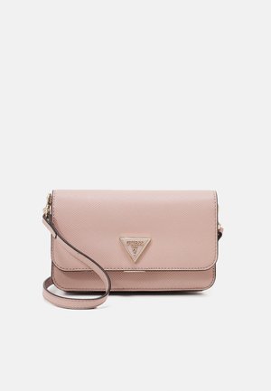 Blush pink textured leather wristlet purse with gold GUESS USA triangular logo plaque on the front flap, isolated on white background.