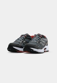 Sapatos de desporto cinzentos com detalhes pretos, parte superior em malha, realces vermelhos e sola branca. Apresentam biqueira arredondada e sola texturizada para melhor tração.