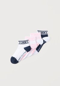 Τέσσερα ζευγάρια κάλτσες αστραγάλου σε λευκό και ροζ με ναυτικό μπλε λεπτομέρειες, με τη λέξη "TOMMY" στις μανσέτες και "TOMMY HILFIGER" στις σόλες.