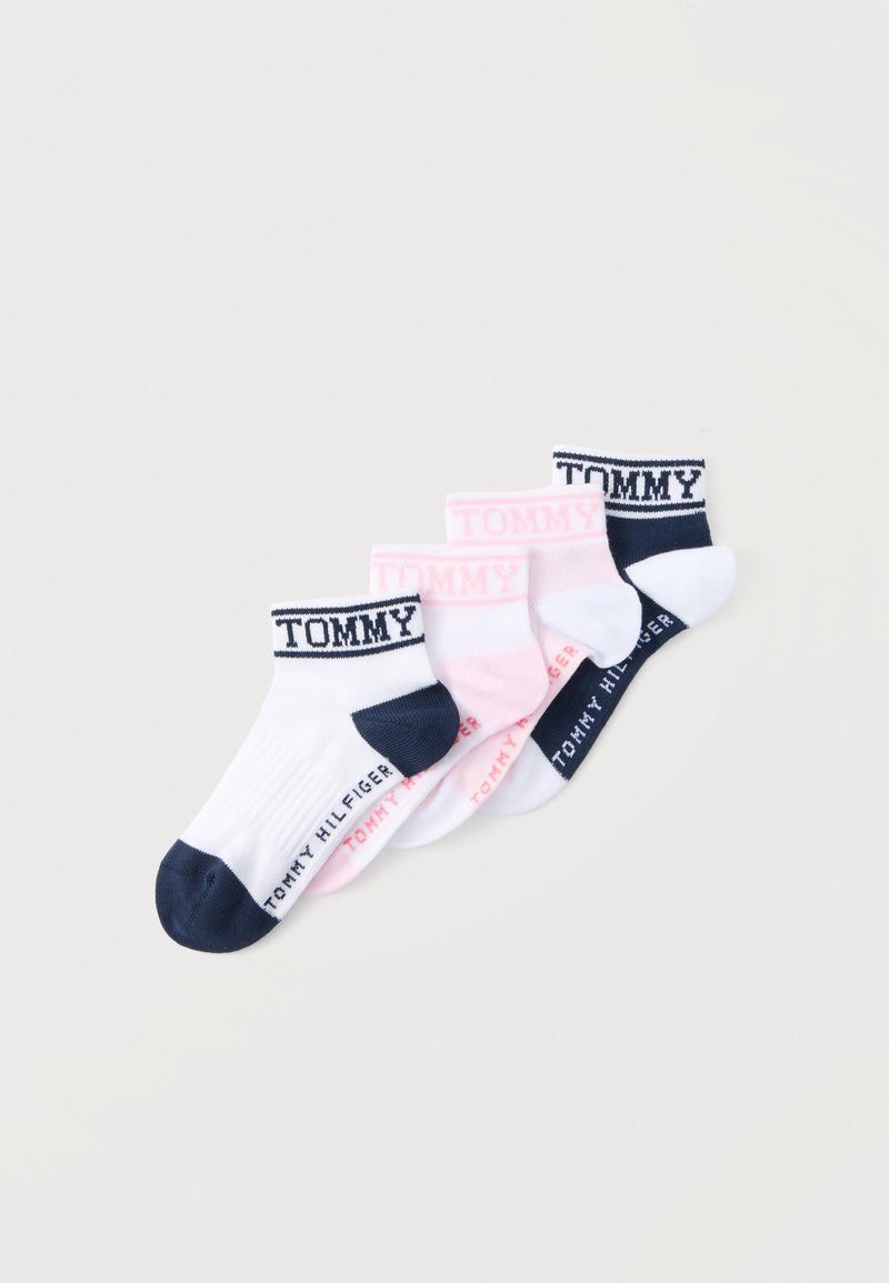 Τέσσερα ζευγάρια κάλτσες αστραγάλου σε λευκό και ροζ με ναυτικό μπλε λεπτομέρειες, με τη λέξη "TOMMY" στις μανσέτες και "TOMMY HILFIGER" στις σόλες.