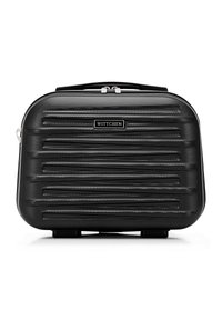 Valise rigide noire avec une finition texturée, dotée de rainures horizontales, d'une poignée supérieure et d'un logo de marque en métal. Fermeture à glissière.