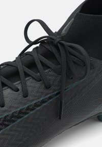 Crampons de football noirs avec une tige synthétique texturée. Dotés de lacets noirs et d'une bande turquoise. Col de type chaussette pour un maintien sûr et une flexibilité.