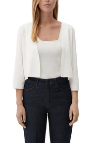 Witte cropped cardigan met driekwart mouwen, gecombineerd met een aansluitend wit topje en donkere hoge taille spijkerbroek. Gladde textuur, eenvoudig ontwerp.