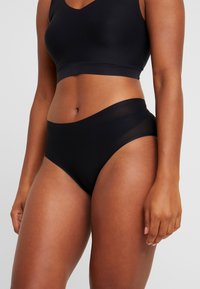 Black seamless bralette and high-waisted underwear set, made of soft fabric with a smooth texture, featuring a simple design without embellishments.