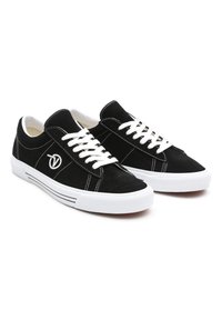 Czarne zamszowe tenisówki z białymi sznurowadłami, białą gumową podeszwą i kontrastowym białym przeszyciem. Na boku znajduje się logo.