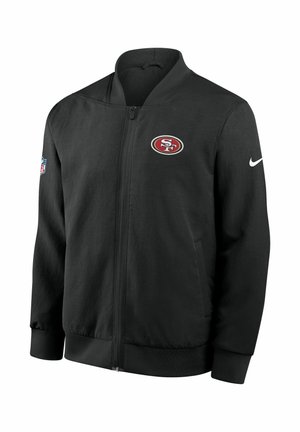 Veste noire zippée en tissu lisse avec un logo des San Francisco 49ers sur la poitrine gauche et un Swoosh Nike sur la manche droite.