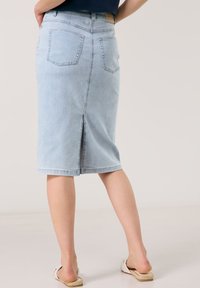 Light blue denim midi skirt with a straight cut, back slit, and two back pockets, featuring stitched detailing along the edges.