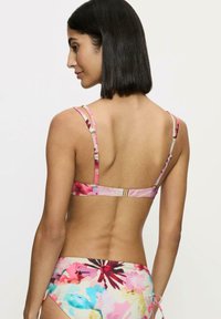 Kwiatowy biustonosz bikini z różowymi ramiączkami, z zapięciem na plecach i wielokolorowym wzorem kwiatowym. Gładka tekstura, lekki materiał i zaokrąglony kształt.
