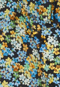 Tissu noir à imprimé floral coloré comprenant des teintes de bleu, jaune, vert et marron. Comprend des boutons noirs et des coutures détaillées.