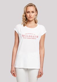 Hvit bomull t-skjorte med rullede korte ermer, med rød tekst som sier "EIE FOR WILDCATS EAST HIGH SCHOOL." En enkel design.