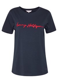 Námořnická modrá tričko s krátkým rukávem vyrobené z bavlny, s červeným kurzivním logem, které zní "tommy Hilfiger" na přední straně.