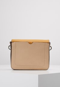 Borsa a tracolla rettangolare beige in pelle con una patta superiore gialla, caratterizzata da una superficie liscia e anello laterale per il fissaggio opzionale della tracolla.