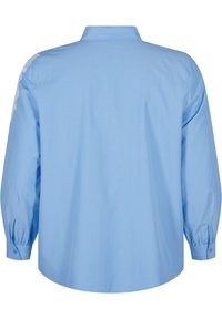 Camicia azzurro chiaro con maniche lunghe, vista posteriore. Presenta un colletto classico, polsini con bottoni e dettagli in pizzo sulla parte superiore del braccio sinistro. Texture liscia.