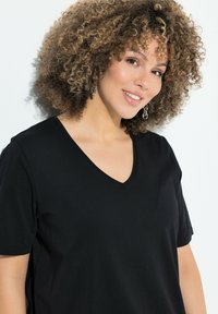 Zwarte V-hals t-shirt met korte mouwen, gemaakt van een zachte, textuurstof. Beschikt over een eenvoudig design, zonder zichtbare patronen of accenten.