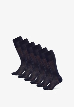 Sechs Paar schwarze Kniestrümpfe, in einer Reihe angeordnet, die ihre Form und Textur vor weißem Hintergrund zeigen.