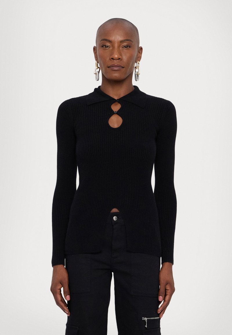 Μαύρο ραφιναρισμένο πλεκτό πουλόβερ με γιακά, με λεπτομέρεια ανοιχτού φρέντου και πλαϊνές σχισμές. Μακριά μανίκια και εφαρμοστή γραμμή. Συνδυάζεται με μαύρες cargo παντούφλες.