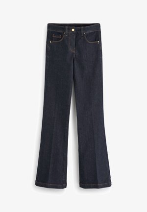 Donkerblauwe spijkerbroek met een uitlopende pijp, voorzien van gouden stiksel en een metalen knoopsluiting. Voorzien van voor- en achterzakken.