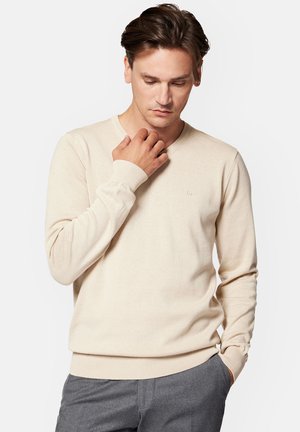 Beżowy sweter w serek z długimi rękawami, z prążkowanymi mankietami i dołem, wykonany z dzianiny, z subtelnym logo na piersi.