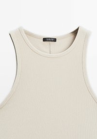Beige žebrovaný bezramínkový top s kulatým výstřihem a štítkem Massimo Dutti, vyrobený v Portugalsku, položený na bílé pozadí.