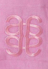 Tessuto rosa con un intricato design ricamato caratterizzato da curve e anelli morbidi, che presenta in modo prominente un monogramma stilizzato di una tonalità più chiara di rosa.